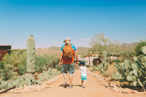 A father and son walking through the desert on a sunny summer day