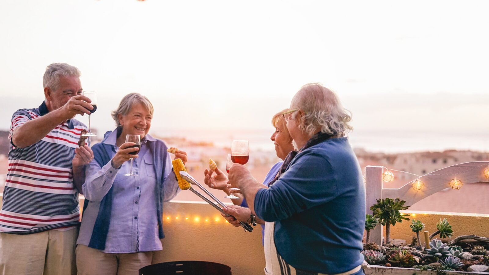 happy senior friends having a barbecue party on a patio